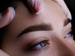 Nahaufnahme eines Gesichts mit betonten Augenbrauen und sanftem Lippen-Make-up.